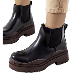Black ankle boots on a brown Gaffney platform