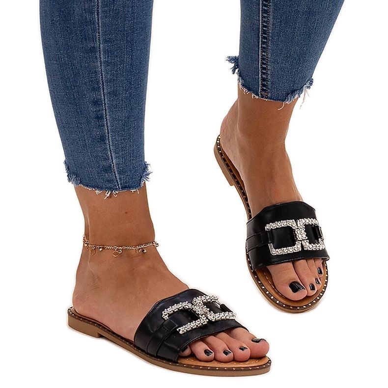 Black flip-flops with a decorative buckle by Rochaela Black flip-flops with a decorative buckle by Rochaela