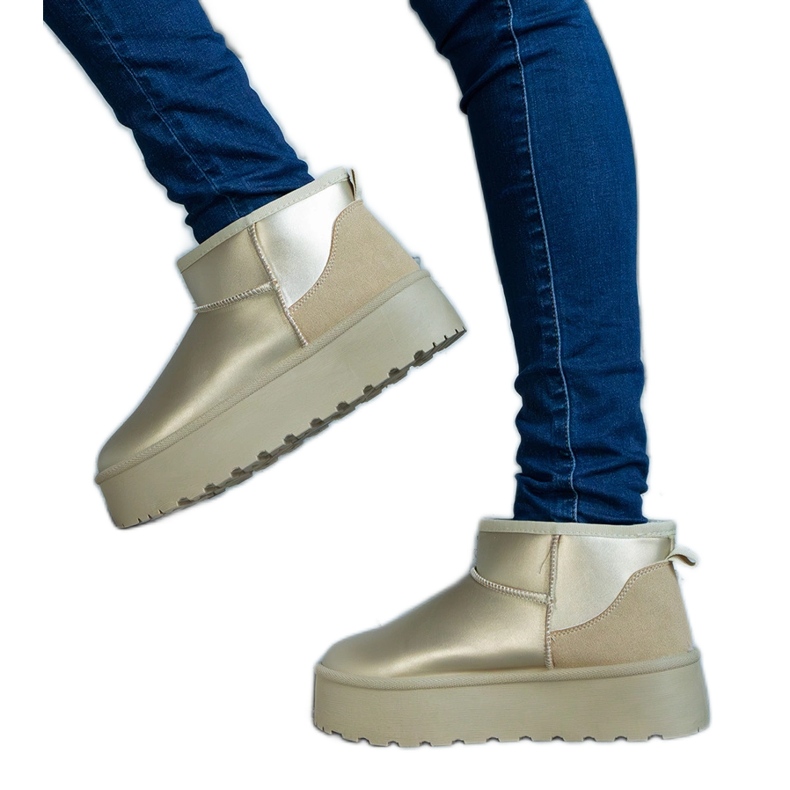 Golden low snow boots on the platform