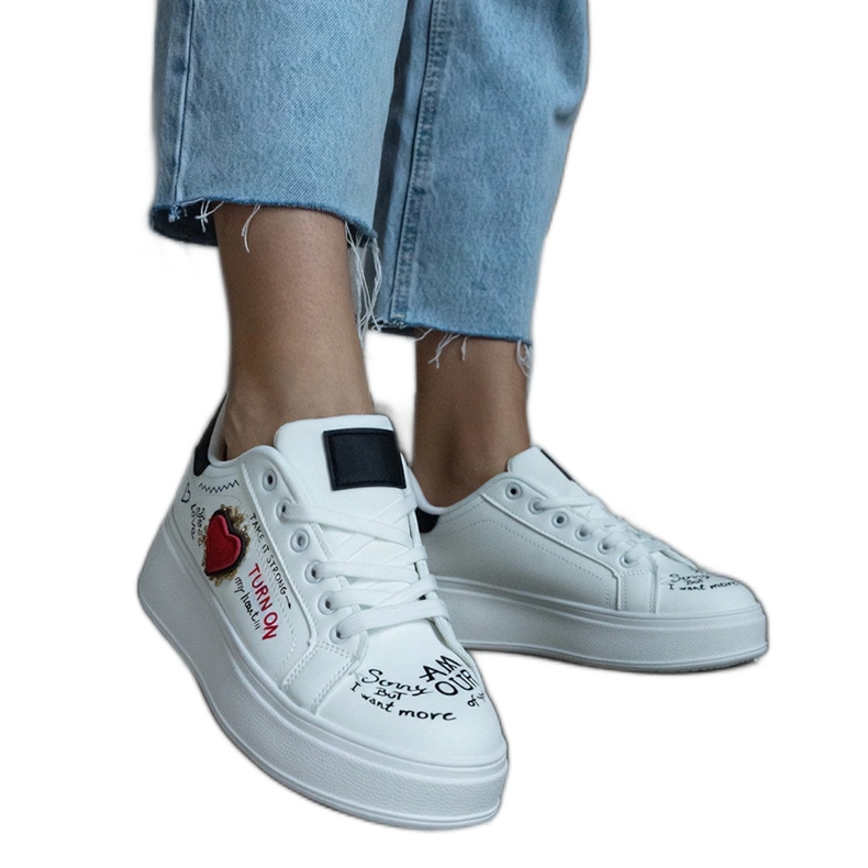 White sneakers decorated with a patch and inscriptions on the platform