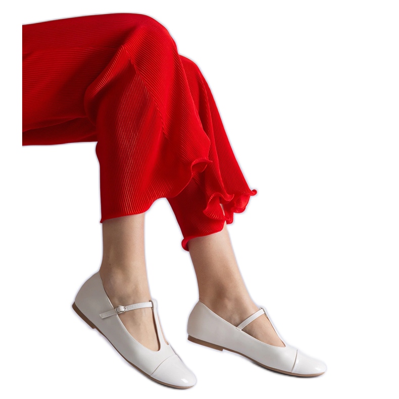 White ballet flats with a patent toe and fastened with a buckle