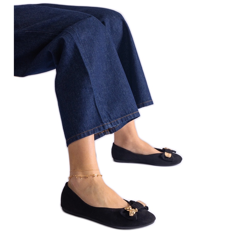 Black ballet flats decorated with a bow and brooch