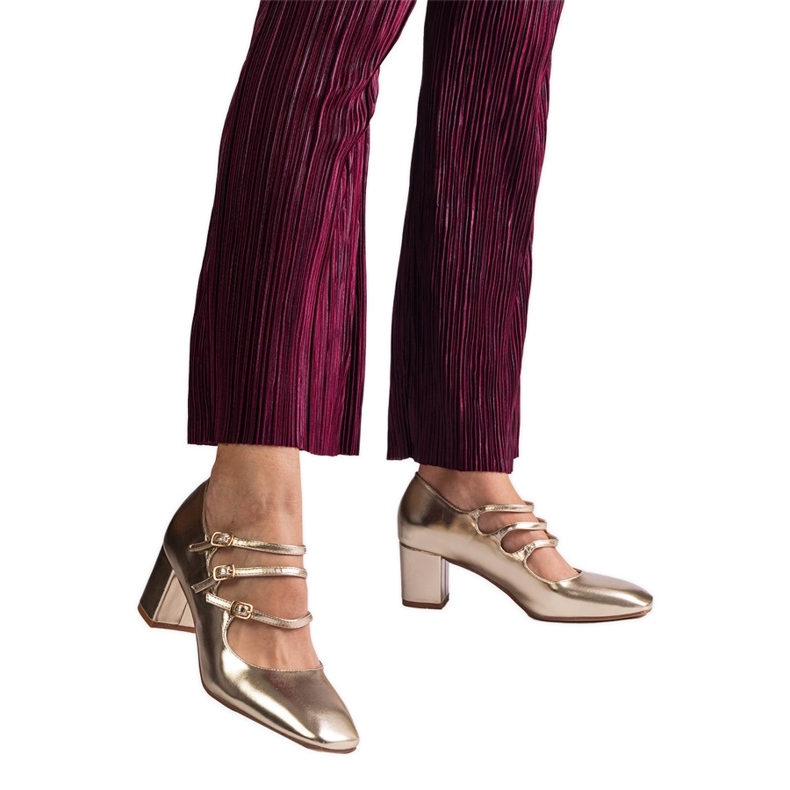 Golden pumps on the post with decorative buckles