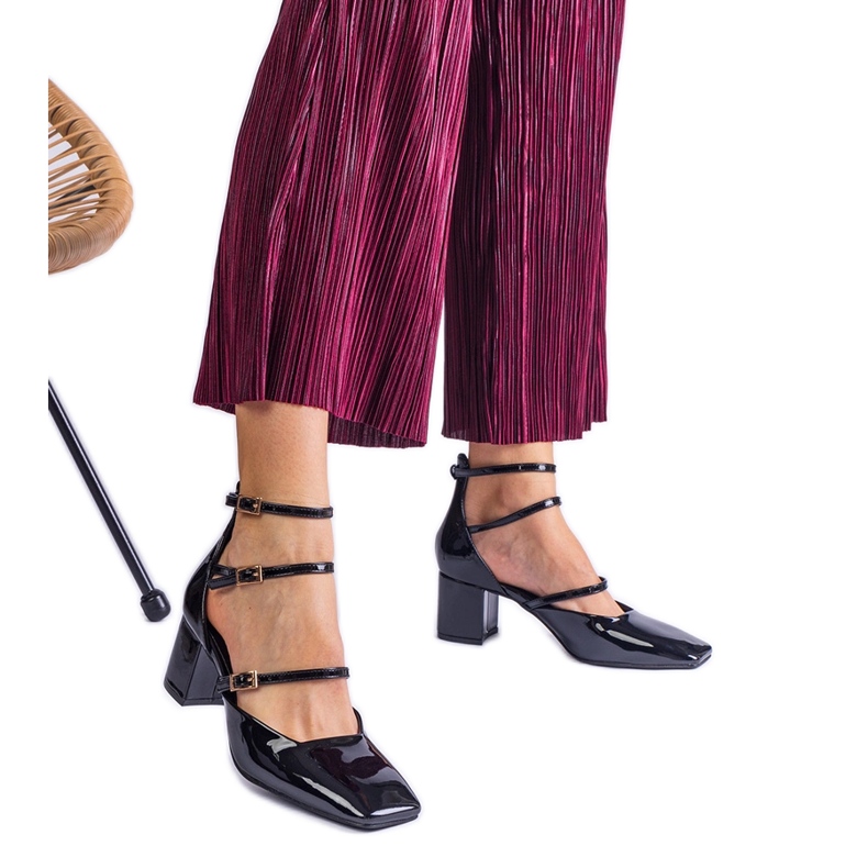 Black pumps varnished on a post with buckles