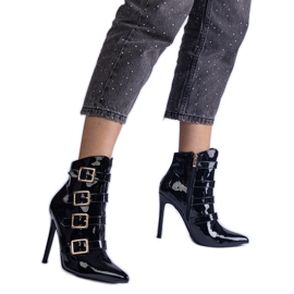 Black boots varnished on a pin with buckles