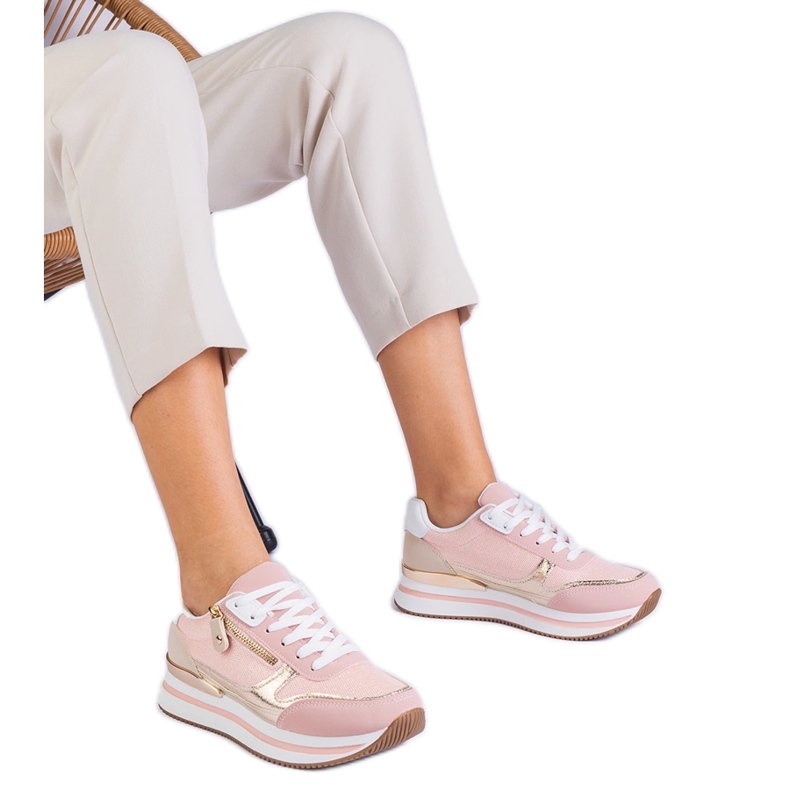Pink sports sneakers on the platform with a golden insertion