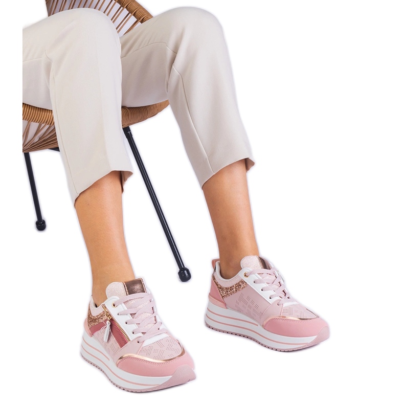 Pink sports sneakers on the platform decorated with glitter