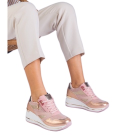 Pink sports sneakers on the platform decorated with glitter and a metallic insert
