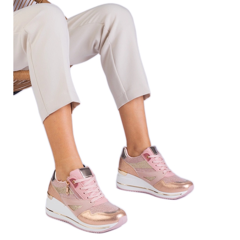 Pink sports sneakers on the platform decorated with glitter and a metallic insert