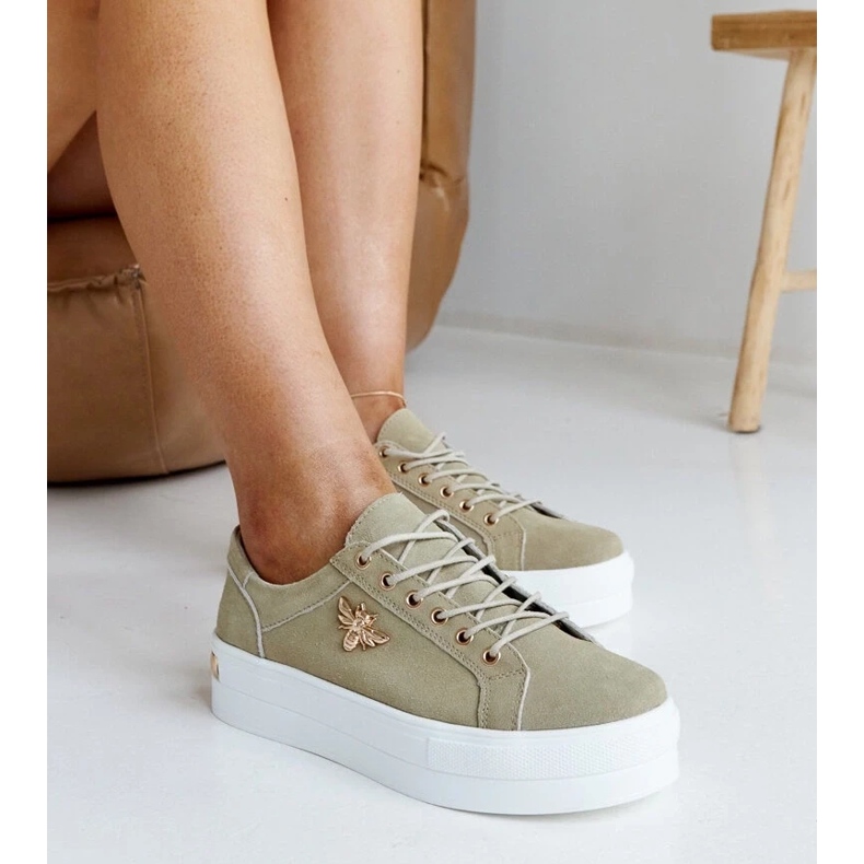 Green leather sneakers on the thick sole of Mikka
