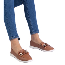 Brown loafers decorated with a bow and a golden teddy bear