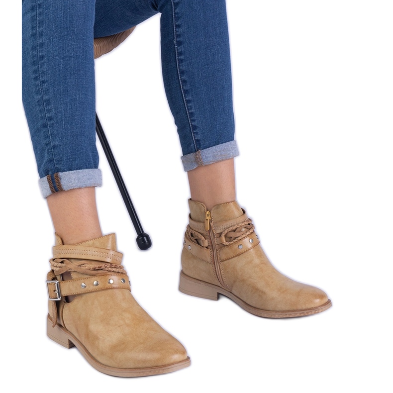 Brown flat boots with a cutout and a buckle