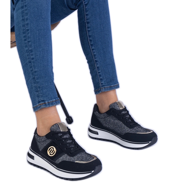 Black sneakers shiny with a golden decoration
