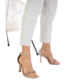 Golden elegant sandals on a high heel decorated with zircons Golden elegant sandals on a high heel decorated with zircons