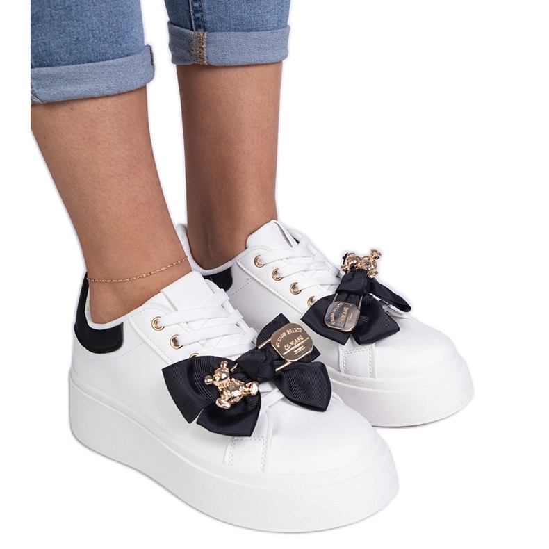 Black sneakers decorated with a bow and a golden teddy bear