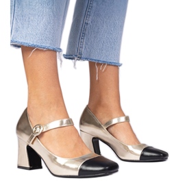 Golden women's pumps with a black nose