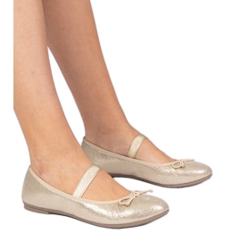 Golden women's ballerinas with a bow on an elastic band