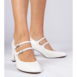 White women's pumps on the pillar with buckles