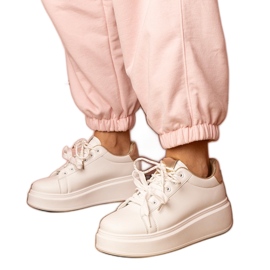 White and gold sports sneakers on the platform White and gold sports sneakers on the platform