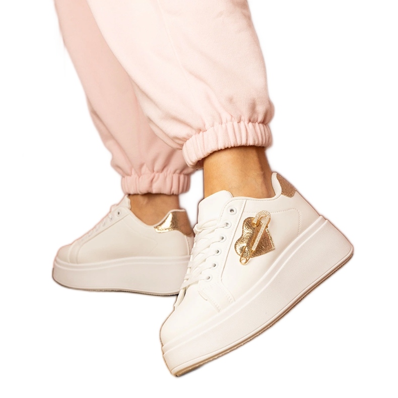 White sneakers with a golden heart and a zircon pins