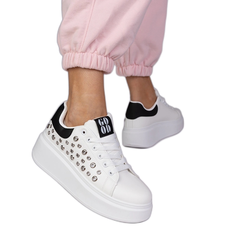 White sneakers with a black insert and studs