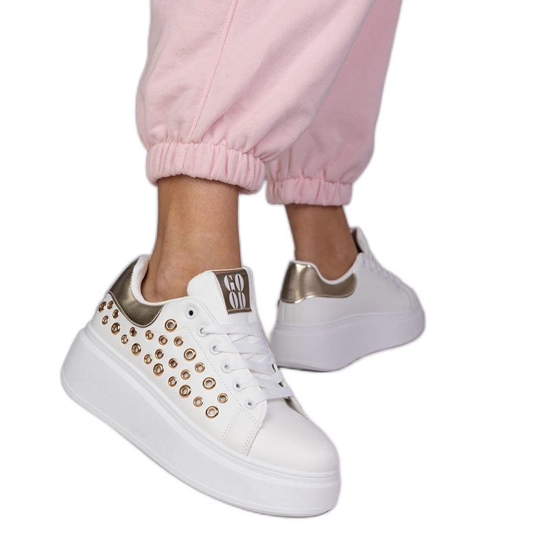 White sneakers with a golden insert and studs