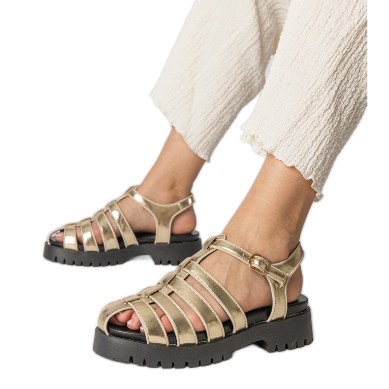 Gold sandals on the platform with a finger line built golden