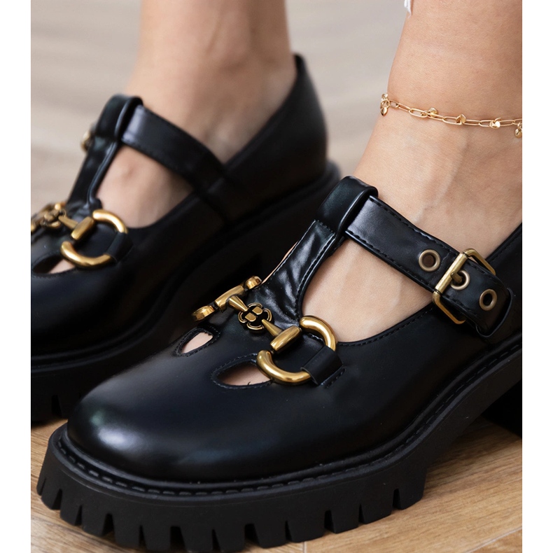 Black shoes on a thick sole with a golden decoration Black shoes on a thick sole with a golden decoration