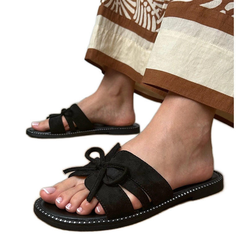 Black flip flops with a bow and decoration at the edges
