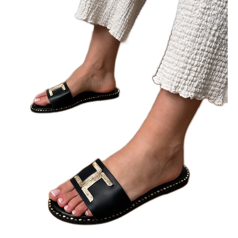 Black flip flops with a golden decoration on the belt