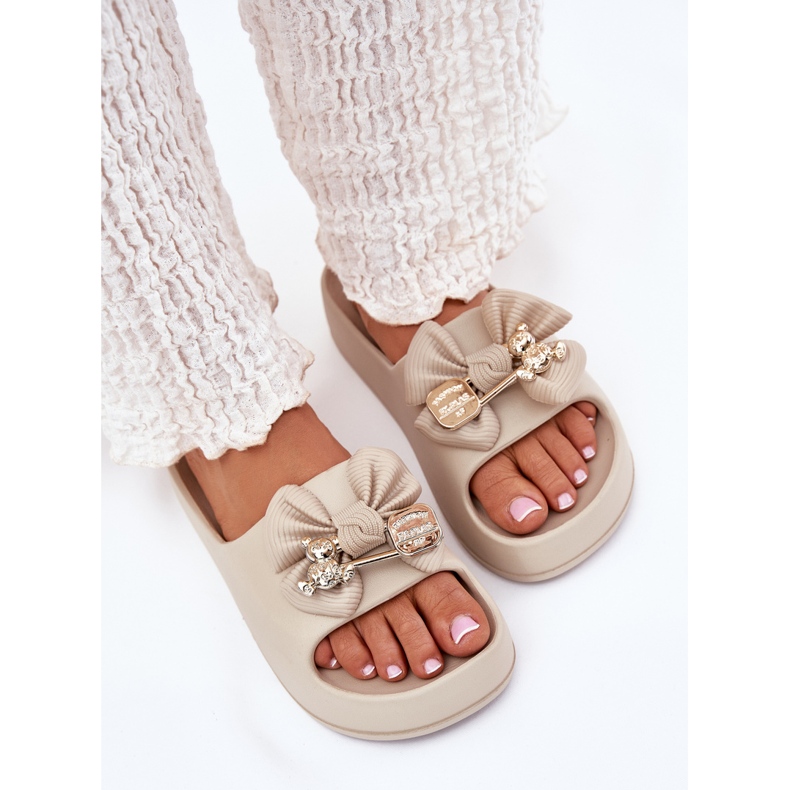 Women's foam flip flops on the platform with a bow and a dark beige brooch