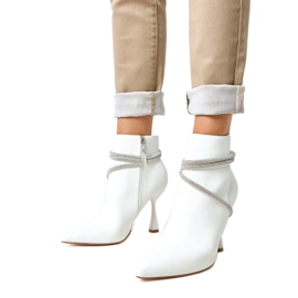 White boots on a high heel decorated with fantaro zircons White boots on a high heel decorated with fantaro zircons