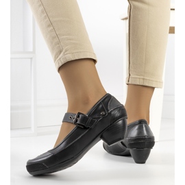 Black pumps fastened with a Via strap 1