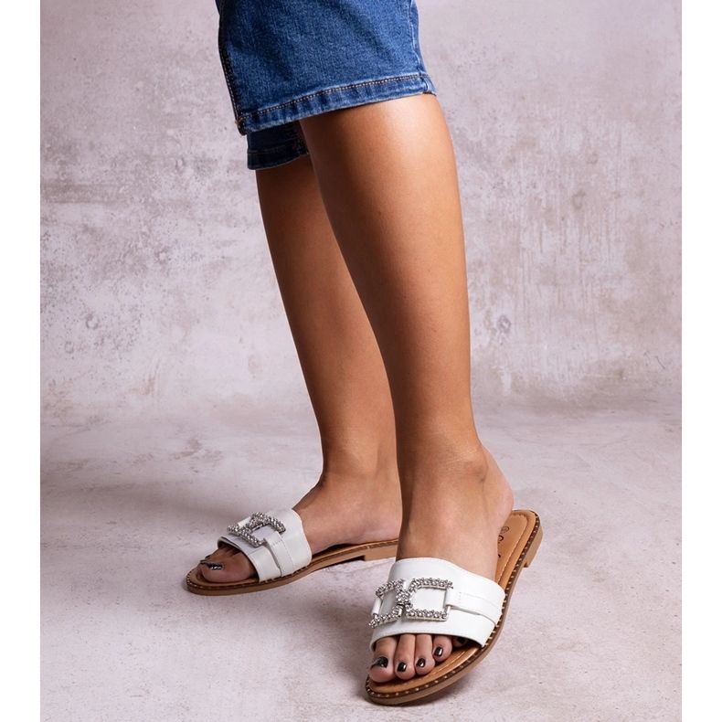White flip-flops with a decorative buckle by Rochaela 1