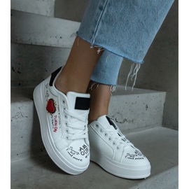 White sneakers decorated with a patch and inscriptions on the platform 1