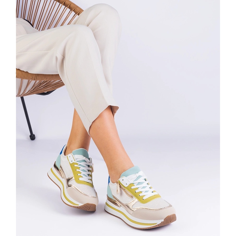 Green sports sneakers on the platform with a golden insertion 2