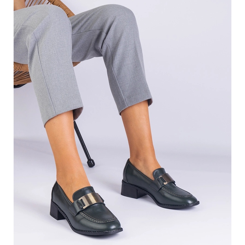 Green shoes on a low post with a metallic decoration 1