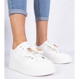 White sneakers decorated with a bow and a golden teddy bear 1