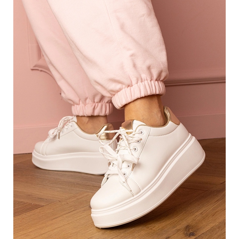 White and gold sports sneakers on the platform 2