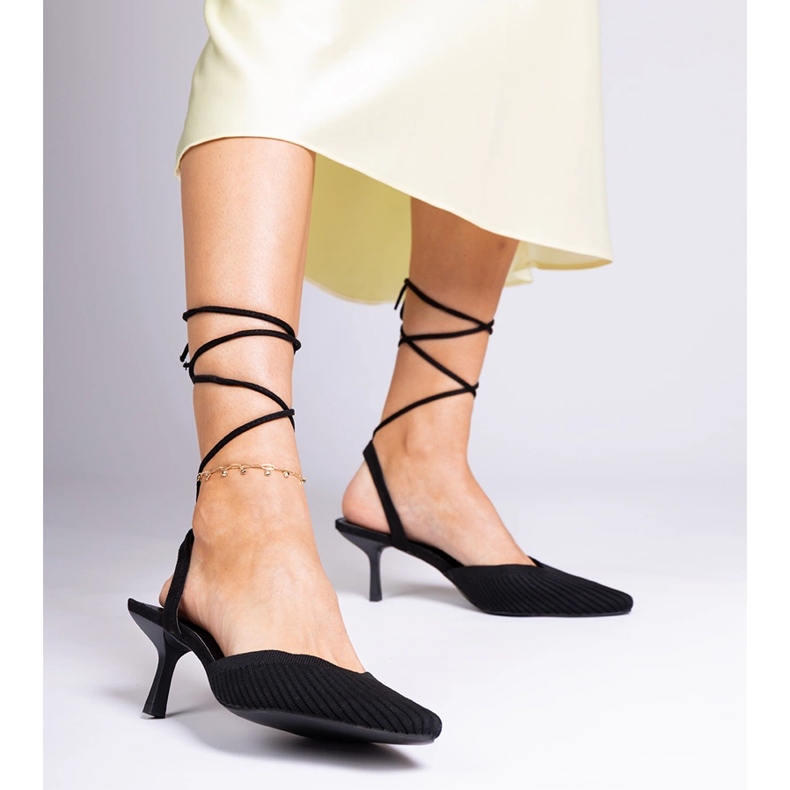 Black material pumps on a high heel with open 1