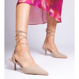 Brown material pumps on a high heel with open 1