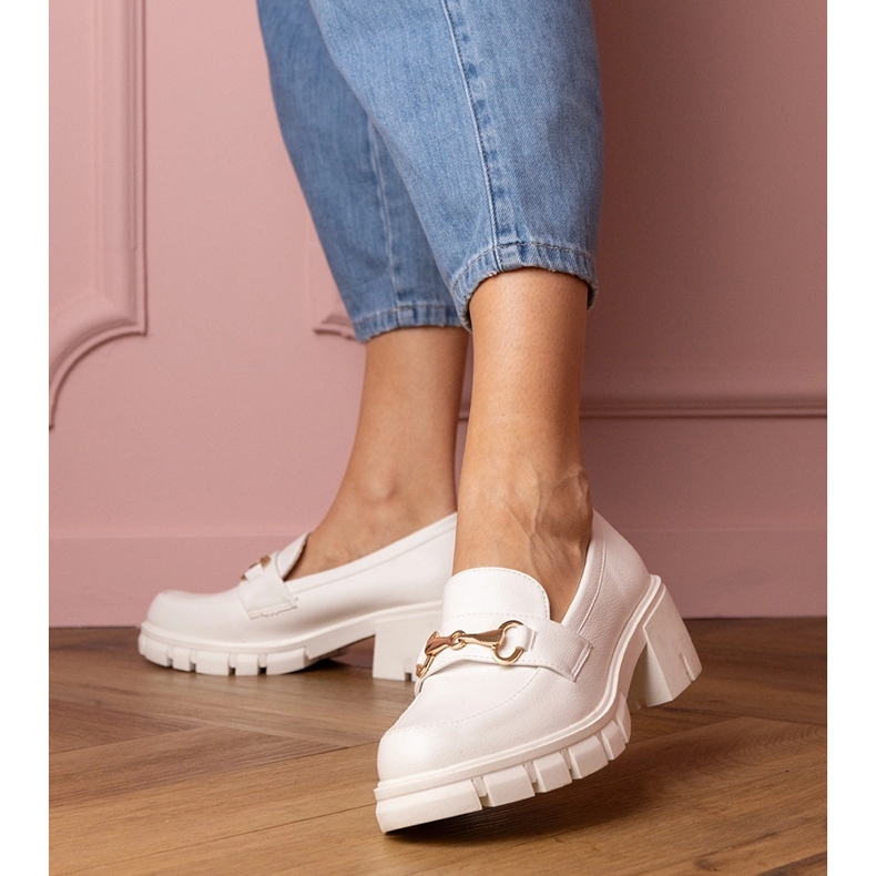 White shoes on a low post with a golden ornament 1 White shoes on a low post with a golden ornament 1