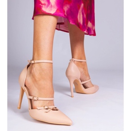 Beige pumps on a high heel fastened around the ankle 1