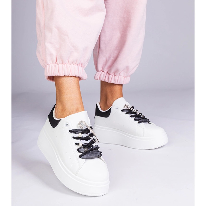 White sneakers with a black insert and a zircon pin 1