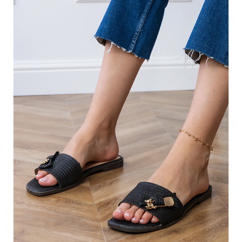 Black flat flip flops with a golden decoration 1