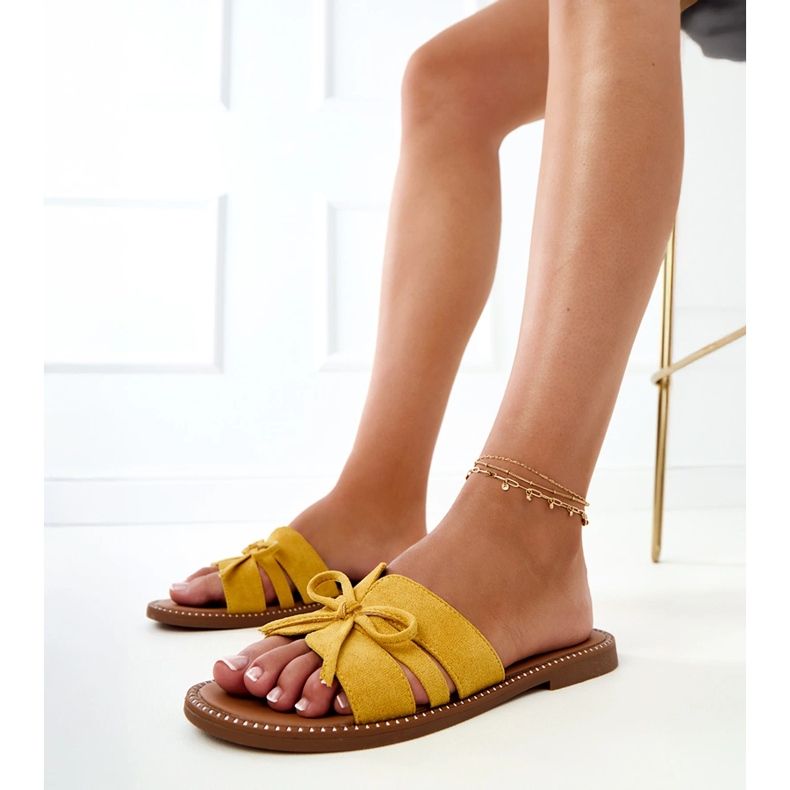 Yellow flip flops with a bow and decoration at the edges 1