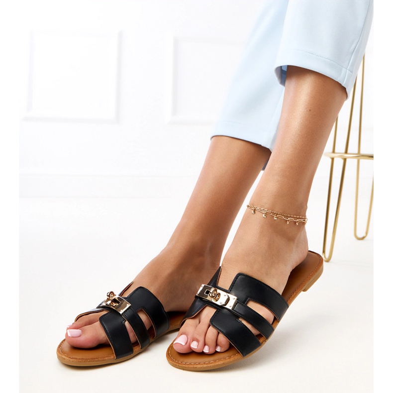 Black flip flops with cutouts on the belt and golden decoration. 1