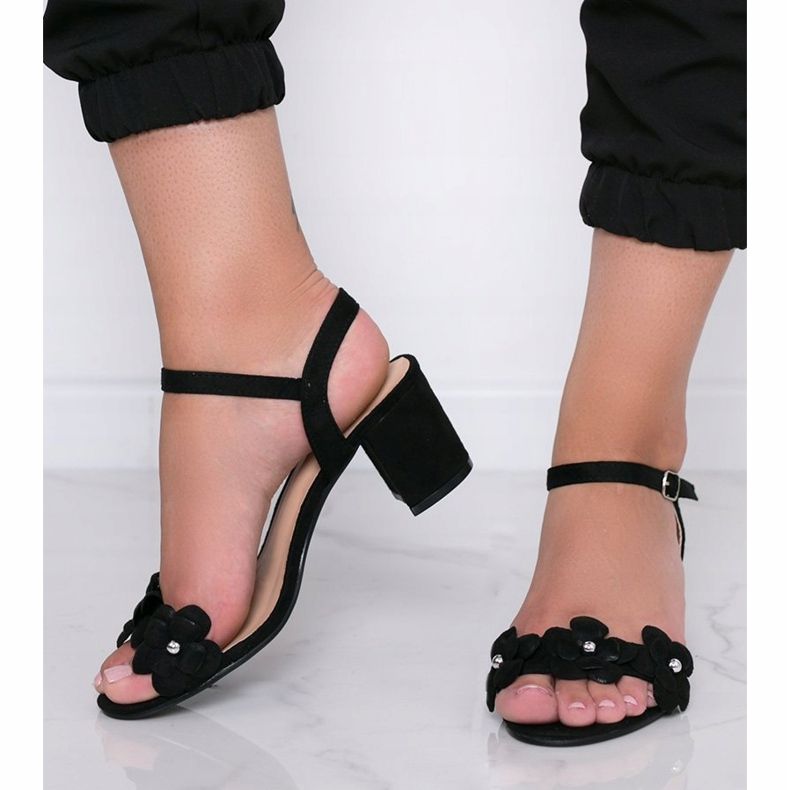 Black sandals on a post with Little Havana flowers 1